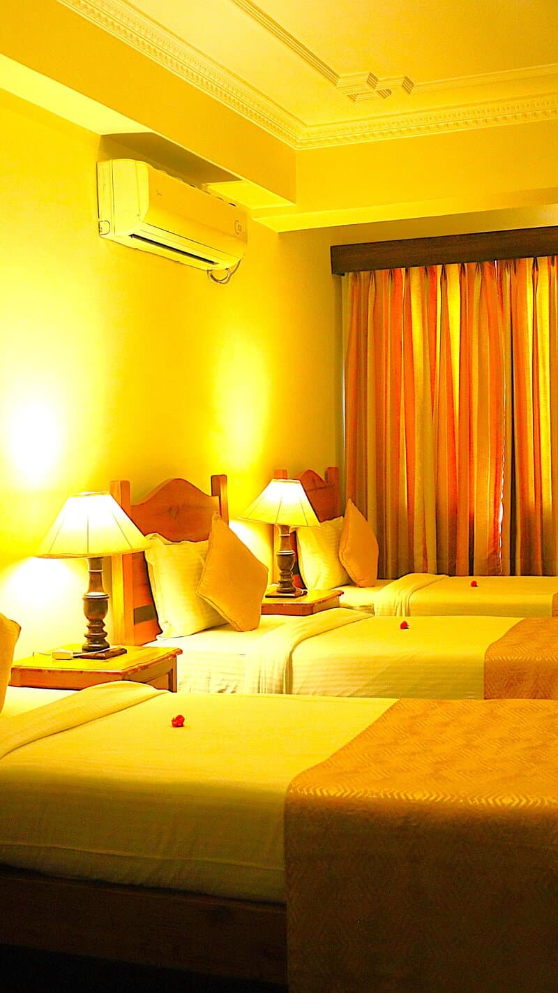 Triple room with three beds and warm lighting